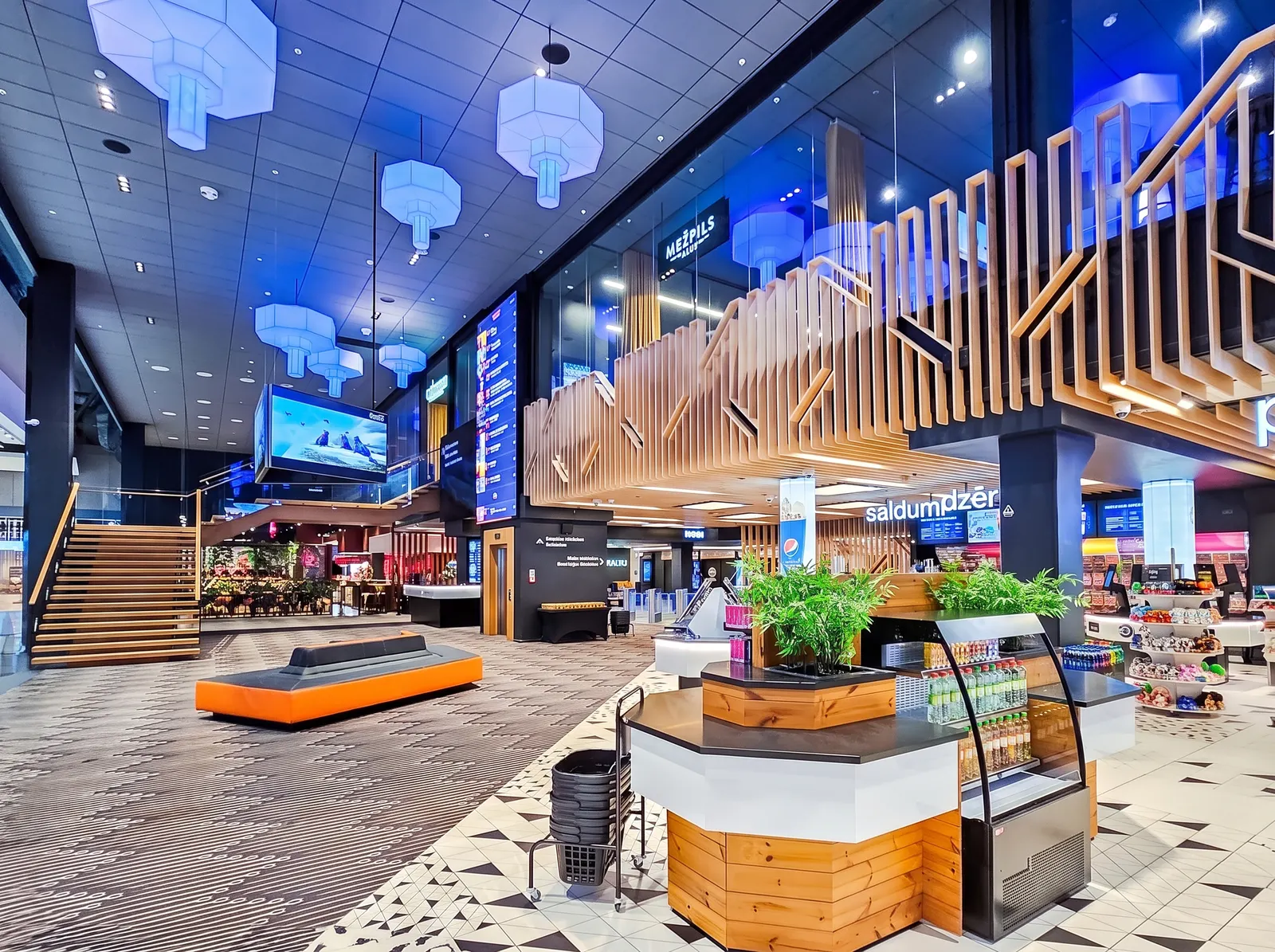 A bright retail lobby with wall displays and digital signage